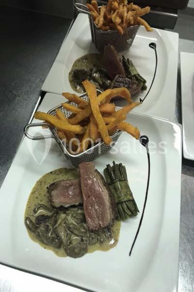 Assiette gastronomique avec viande, sauce crémeuse, fagot de haricots verts et frites servies dans une petite corbeille.