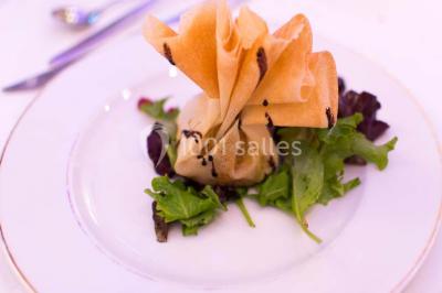 Dessert raffiné composé d'une mousse rose, d'une sauce rouge en verrine et d'un carré de chocolat décoratif.