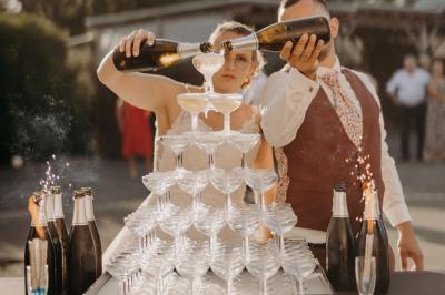 Dessert raffiné composé d'une mousse rose, d'une sauce rouge en verrine et d'un carré de chocolat décoratif.