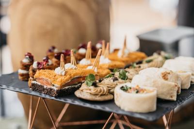 Dessert raffiné composé d'une mousse rose, d'une sauce rouge en verrine et d'un carré de chocolat décoratif.