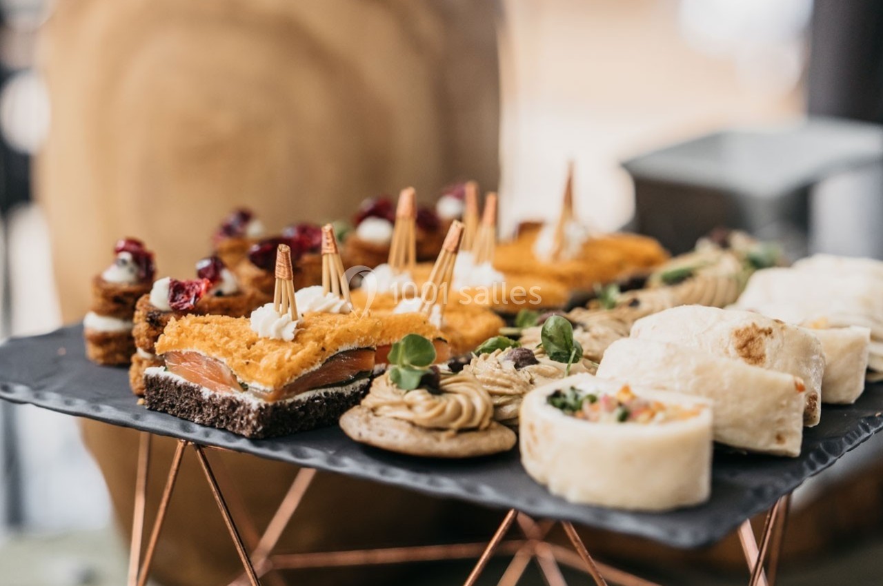 Plateau de bouchées salées variées, incluant des roulés, des tartines et des amuse-bouches décorés.