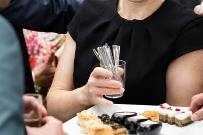 Dessert raffiné composé d'une mousse rose, d'une sauce rouge en verrine et d'un carré de chocolat décoratif.
