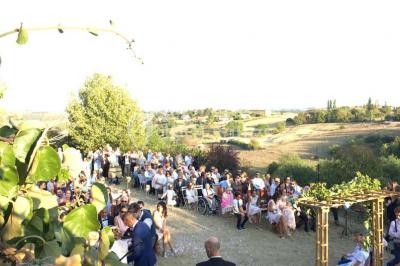 Montgolfière verte posée sur un chemin de terre entouré de végétation sous un ciel nuageux.