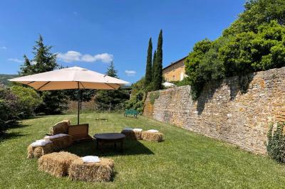 Montgolfière verte posée sur un chemin de terre entouré de végétation sous un ciel nuageux.