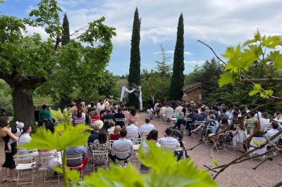 Montgolfière verte posée sur un chemin de terre entouré de végétation sous un ciel nuageux.