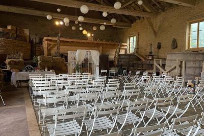 Montgolfière verte posée sur un chemin de terre entouré de végétation sous un ciel nuageux.
