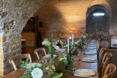 Montgolfière verte posée sur un chemin de terre entouré de végétation sous un ciel nuageux.
