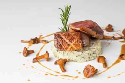 Tables décorées pour un événement en plein air, disposées devant une maison aux volets bleus et murs couverts de lierre.
