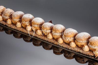 Tables décorées pour un événement en plein air, disposées devant une maison aux volets bleus et murs couverts de lierre.