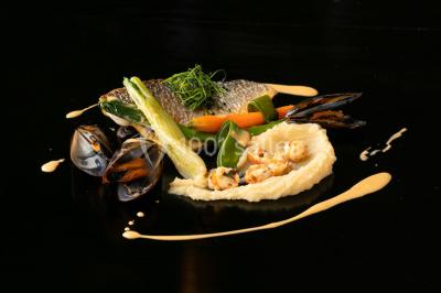 Tables décorées pour un événement en plein air, disposées devant une maison aux volets bleus et murs couverts de lierre.