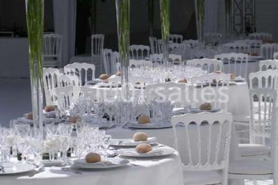 Gros plan sur un macaron rouge garni de crème blanche, posé sur une surface sombre.