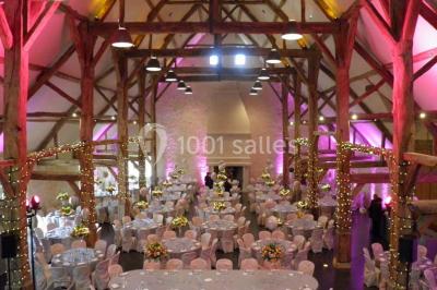 Gros plan sur un macaron rouge garni de crème blanche, posé sur une surface sombre.