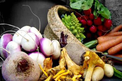 Plateaux de mets raffinés comprenant macarons colorés, légumes variés et charcuterie, présentés par un traiteur.