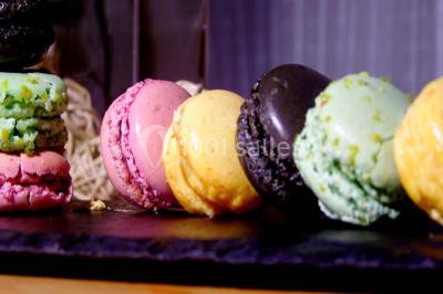 Plateaux de mets raffinés comprenant macarons colorés, légumes variés et charcuterie, présentés par un traiteur.