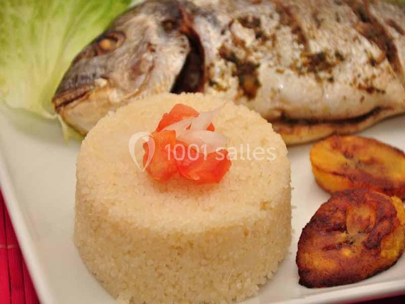 Plat composé de poisson grillé, semoule garnie de dés de tomate et oignon, accompagné de bananes plantains frites.
