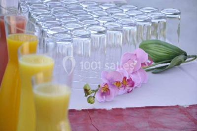 Un couple coupe un gâteau de mariage entouré de desserts décorés et de cierges magiques allumés.