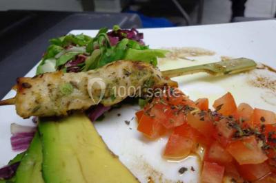 Plateau de verrines colorées garnies de fruits frais comme kiwi, fraise et mangue, tenu par une personne.