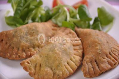 Plateau de verrines colorées garnies de fruits frais comme kiwi, fraise et mangue, tenu par une personne.