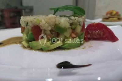 Plateau de verrines colorées garnies de fruits frais comme kiwi, fraise et mangue, tenu par une personne.