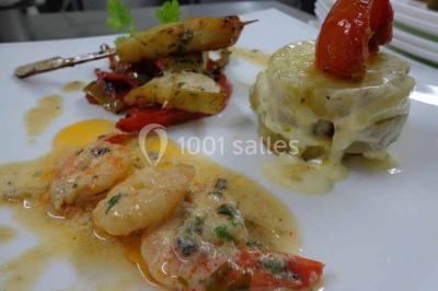 Plateau de verrines colorées garnies de fruits frais comme kiwi, fraise et mangue, tenu par une personne.