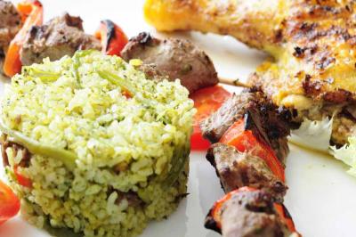 Plateau de verrines colorées garnies de fruits frais comme kiwi, fraise et mangue, tenu par une personne.