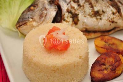 Plateau de verrines colorées garnies de fruits frais comme kiwi, fraise et mangue, tenu par une personne.