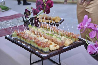 Plateau de verrines colorées garnies de fruits frais comme kiwi, fraise et mangue, tenu par une personne.