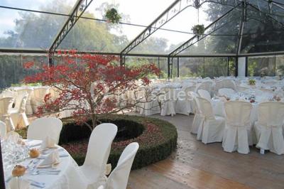 Boule croustillante sur lit de salade, garnie d'une framboise et décorée de sauce rouge sur assiette blanche.