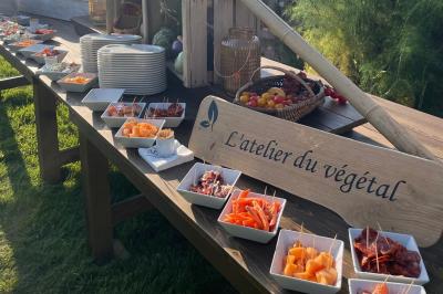 Plateau de bouchées apéritives variées avec charcuterie, légumes, verrines et décorations colorées.