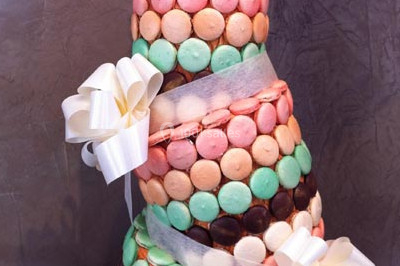 Assiette gastronomique avec trois noix de Saint-Jacques sur des légumes colorés, décorée de fines tranches et d'herbes.