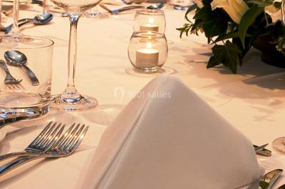 Tranche de viande cuite accompagnée de haricots verts, carottes et gouttes de sauce sur une assiette blanche.