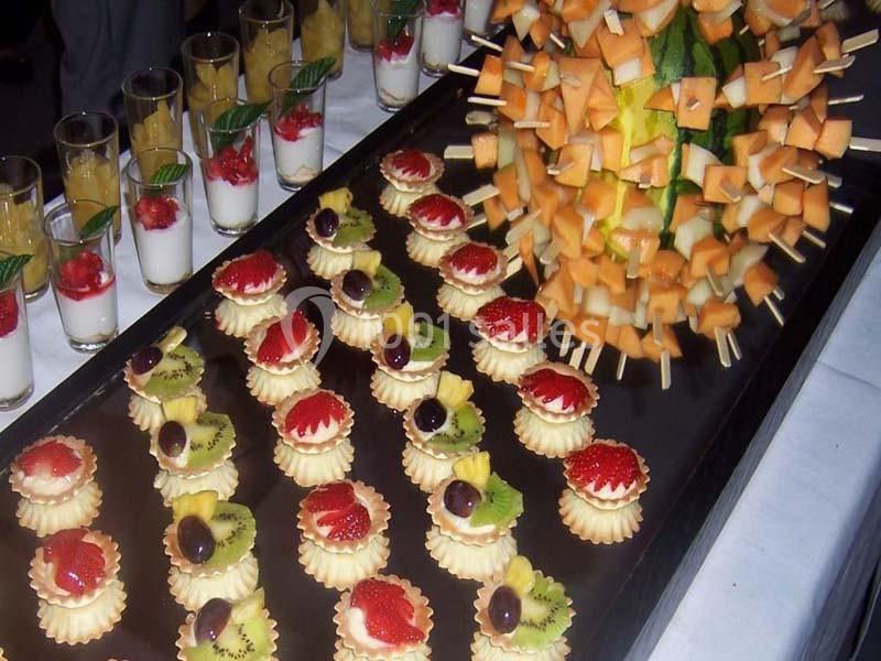 Plateau de desserts avec tartelettes aux fruits variés, verrines de panna cotta et brochettes de fruits sur un ananas.