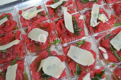 Rouleau de saumon, mangue et concombre présenté sur une petite assiette en bois.