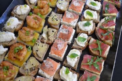 Rouleau de saumon, mangue et concombre présenté sur une petite assiette en bois.