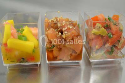 Rouleau de saumon, mangue et concombre présenté sur une petite assiette en bois.