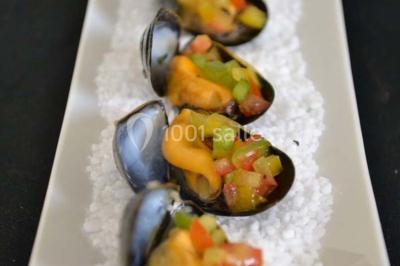 Rouleau de saumon, mangue et concombre présenté sur une petite assiette en bois.