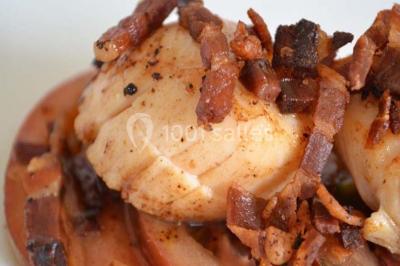 Rouleau de saumon, mangue et concombre présenté sur une petite assiette en bois.