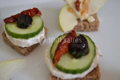 Rouleau de saumon, mangue et concombre présenté sur une petite assiette en bois.