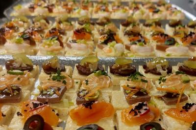 Rouleau de saumon, mangue et concombre présenté sur une petite assiette en bois.