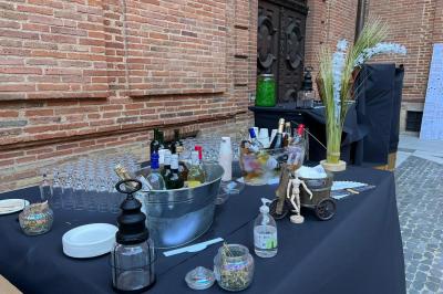 Décoration d'une tente événementielle avec tables ornées, barils en bois, fleurs et ballons dans un espace extérieur.