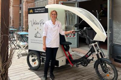 Décoration d'une tente événementielle avec tables ornées, barils en bois, fleurs et ballons dans un espace extérieur.