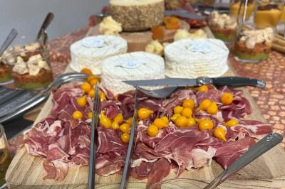 Décoration d'une tente événementielle avec tables ornées, barils en bois, fleurs et ballons dans un espace extérieur.