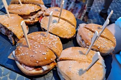 Décoration d'une tente événementielle avec tables ornées, barils en bois, fleurs et ballons dans un espace extérieur.