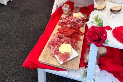 Décoration d'une tente événementielle avec tables ornées, barils en bois, fleurs et ballons dans un espace extérieur.