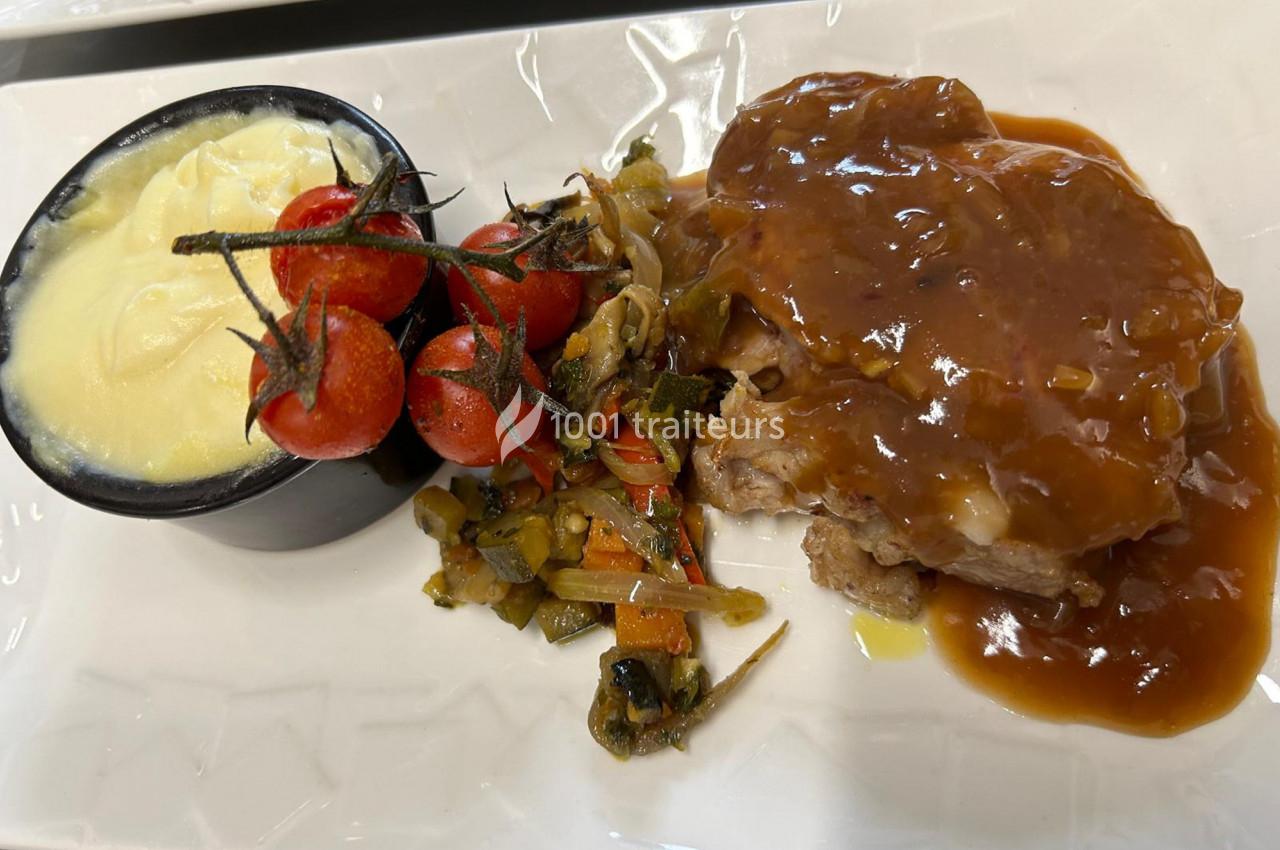 Assiette composée de viande en sauce, purée crémeuse, tomates cerises rôties et légumes sautés.