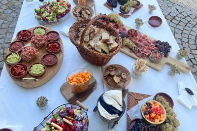 Décoration d'une tente événementielle avec tables ornées, barils en bois, fleurs et ballons dans un espace extérieur.