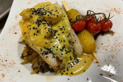 Décoration d'une tente événementielle avec tables ornées, barils en bois, fleurs et ballons dans un espace extérieur.