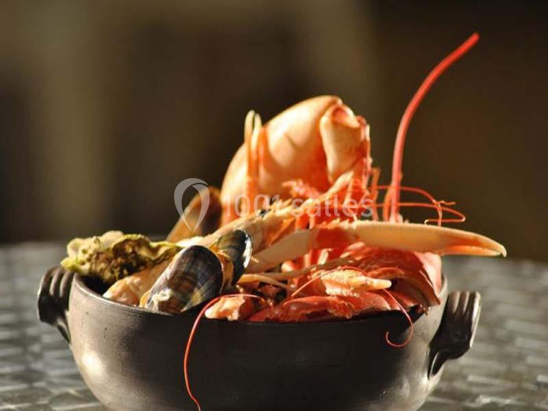 Assortiment de fruits de mer dans un bol en céramique, comprenant crevettes, crabe et coquillages.