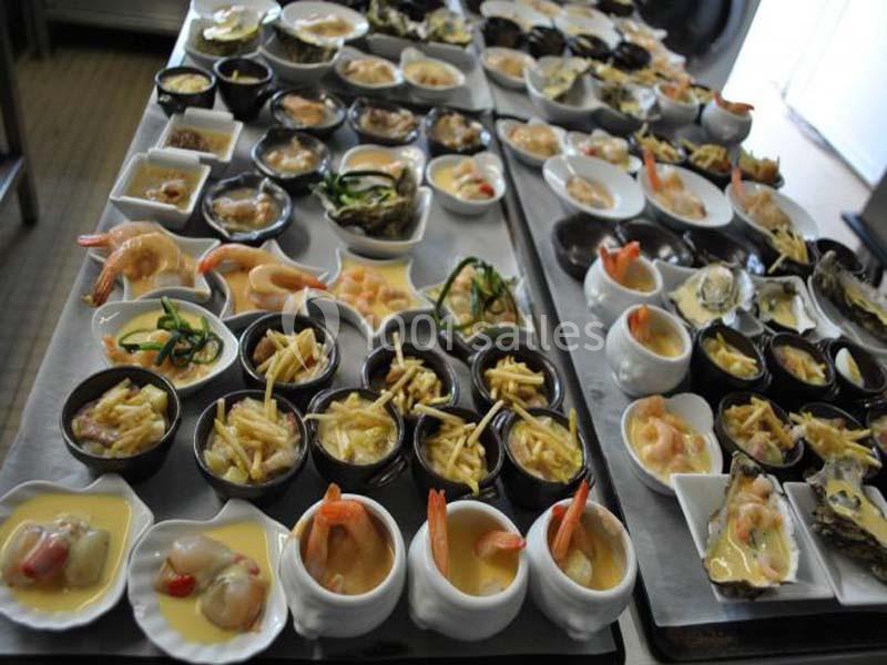 Plateaux garnis de verrines et petits plats variés, incluant fruits de mer, légumes et accompagnements.