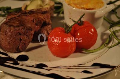 Assiette de poisson en sauce blanche, garnie de persil frais, légumes et décorée de traits de sauce verte.